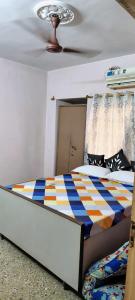 a bedroom with a bed with a colorful comforter at Anand Vihar in kolkata