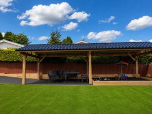 a wooden pavilion with a table and a playground at Ty Ray Penmaes in Rhayader