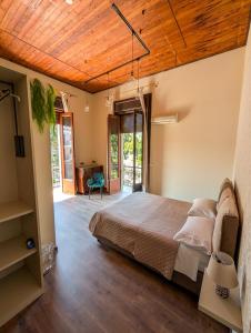 a bedroom with a bed and a wooden ceiling at Villa Luisetta Palmi in Palmi