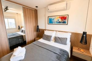 a hotel room with a bed and a mirror at Noble Studio 22209, Piscina, Vaga, Academia, Ar in Guarulhos +55 photos