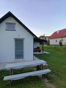 a picnic bench in front of a white building at Domček u Alberta in Vrbov