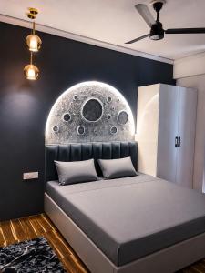 a bedroom with a bed with a moon mural on the wall at Canvas and Cabana - Cabo in Sonīpat