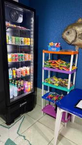 a refrigerator filled with food next to a table at Pousada Mar e Sol in Peruíbe