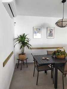 a dining room with a table and a potted plant at La OSTRA 33 in Chiclana de la Frontera