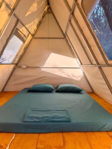 a bed in a tent with two pillows in it at Borsh Olive Camping in Borsh