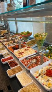 a buffet line with many different types of food at Studio com sacada, piscina e academia a 25 min Aeroporto GRU in São Paulo