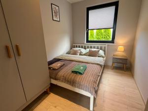 a small bedroom with a bed and a window at Domki Weekend in Łeba +27 photos