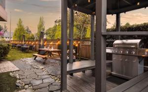 a backyard patio with a grill and a table at Coast Parksville Hotel in Parksville