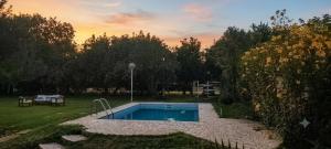 a small swimming pool in a yard with a sunset at Ayün Mawida in Las Compuertas