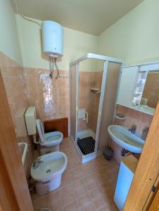 a bathroom with two toilets and a shower and a sink at Villa Luisetta Palmi in Palmi