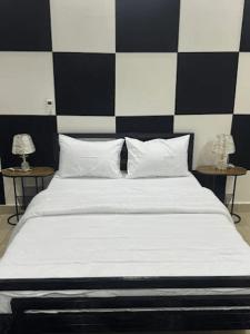 a bedroom with a bed with black and white checkered wall at Hôtel La Parisienne in Louga