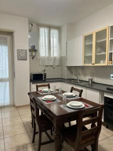 a kitchen with a wooden table and chairs in it at 120 mq trilocale e terrazzo in Moncalieri