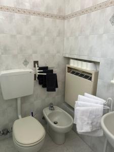 a white bathroom with a toilet and a sink at 120 mq trilocale e terrazzo in Moncalieri +12 photos