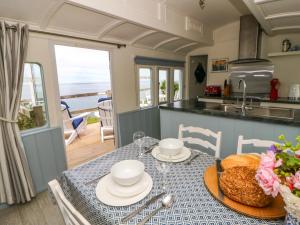 a kitchen with a table with a plate of food at Clifftop Carriage in Aberporth