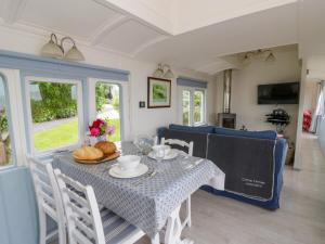 a dining room with a table and chairs and a couch at Clifftop Carriage in Aberporth
