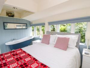 a bedroom with a bed and a tub and a sink at Clifftop Carriage in Aberporth