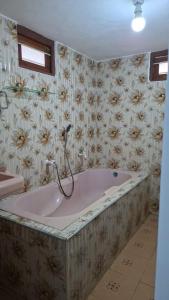a bath tub in a bathroom with flowers on the wall at SN Villa in Jaffna