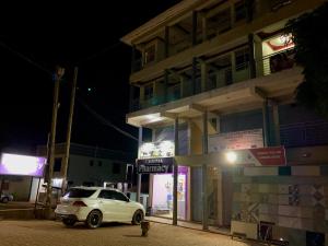 a white car parked outside of a building at night at Highway sunset in Namulanda