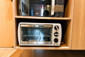 a microwave oven sitting inside of a cabinet at Noble Studio 22209, Piscina, Vaga, Academia, Ar in Guarulhos