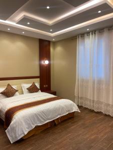 a bedroom with a large bed and a window at شالية خاص in Khamis Mushayt