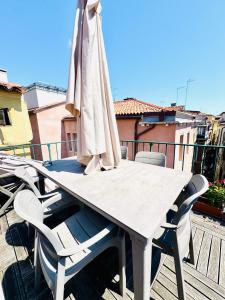 a table with an umbrella and chairs on a balcony at San Marco Romantic Views in Venice