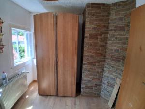 a wooden cabinet in a room with a brick wall at Fewo am Wasserrad in Ruhla