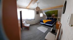 a small room with a blue bed and a chair at Fewo am Wasserrad in Ruhla