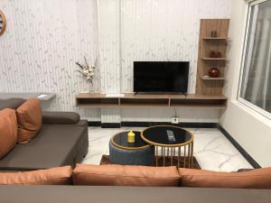 a living room with a couch and a television at 1 Bed Apartment in Murree in Murree