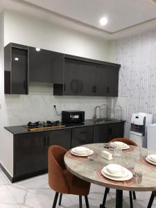 a kitchen with a table and two chairs and a counter at 1 Bed Apartment in Murree in Murree