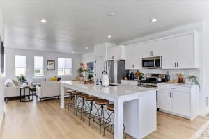 a kitchen with white cabinets and a large island with bar stools at Stylish Pet Friendly Home for Work & Relaxation in American Fork