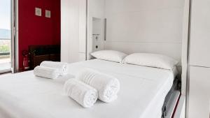 a white bedroom with two beds with towels on them at oasi relax Jacuzzi ultimo piano in Turin