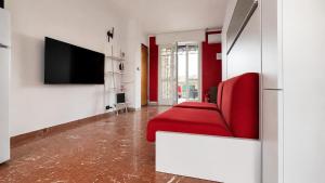 a living room with a red couch and a flat screen tv at oasi relax Jacuzzi ultimo piano in Turin
