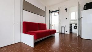 a red couch in a white living room at oasi relax Jacuzzi ultimo piano in Turin