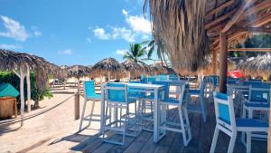 a group of blue chairs and tables on the beach at Beach Veranda Hotel Punta Cana in Punta Cana