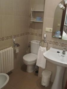 a bathroom with a white toilet and a sink at Pensión Chiquilla in O Grove