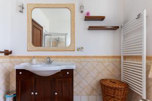 a bathroom with a sink and a mirror at Casa Konny in Gonnostramatza +30 photos