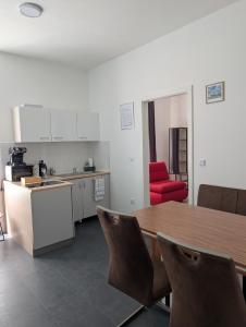 a kitchen with a wooden table and a red chair at Royal Racing Suite Top 3 near Red Bull Ring in Judenburg