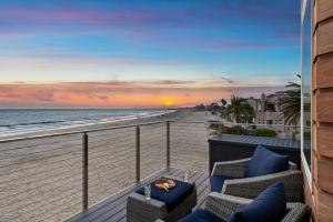 a balcony with chairs and a view of the beach at Sandcastle in Carpinteria