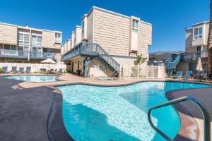 a swimming pool in front of a apartment building at Seaside Retreat at Solimar Sands in Carpinteria
