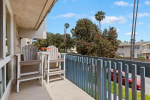 two chairs on a porch with a fence at Seaside Retreat at Solimar Sands in Carpinteria