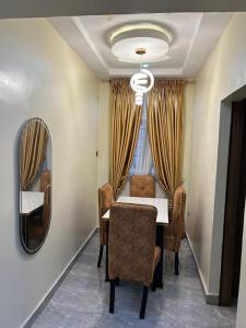 a dining room with a table and a mirror at ACCENT HOMES Apartment in Asaba +2 photos
