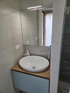 a bathroom with a white sink and a mirror at Casa Vacanza Largo 65 in Scorrano
