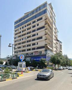 a car parked in front of a large building at Shtepi ditore elbasan in Elbasan