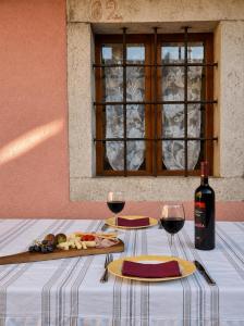 a table with two glasses of wine and a plate of food at Hisa pri Ovcicevih in Komen