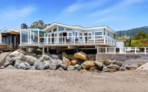 a house on the beach with rocks in front of it at Padaro Sands in Carpinteria