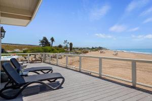 a bench sitting on a porch overlooking the beach at Padaro Sands in Carpinteria