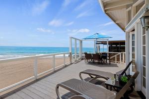 a balcony with a table and chairs on the beach at Padaro Sands in Carpinteria