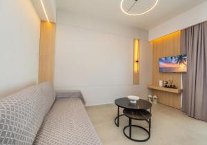 a living room with a bed and a table at Sunrise suites in Kallithea Halkidikis