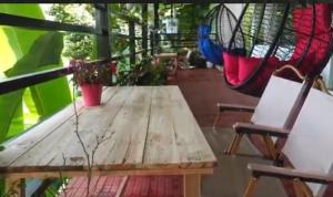 a wooden table and a hammock on a porch at KarSa Woods, Kodaikanal in Perumālmalai +39 photos