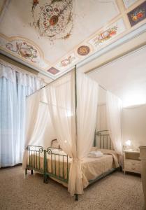 een slaapkamer met een bed met gordijnen en een plafond bij Novella House in Florence